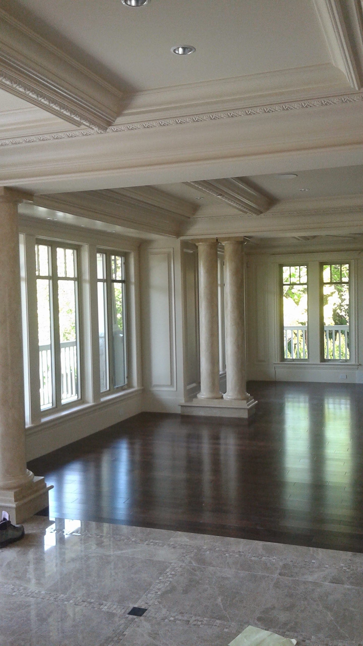 Grand interior with columns, coffered ceilings, and hardwood floors