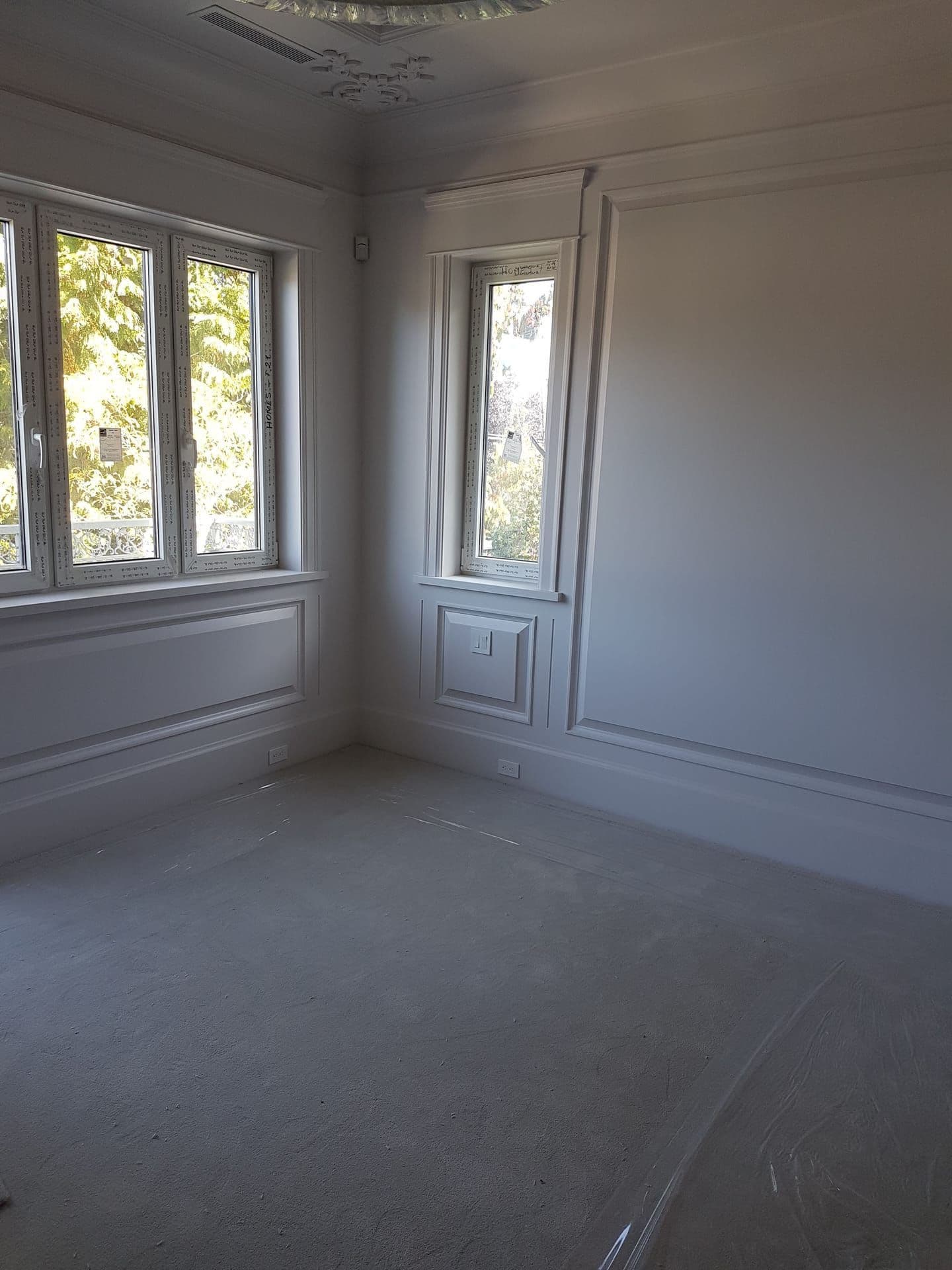 Interior room with custom crown moulding and tall windows